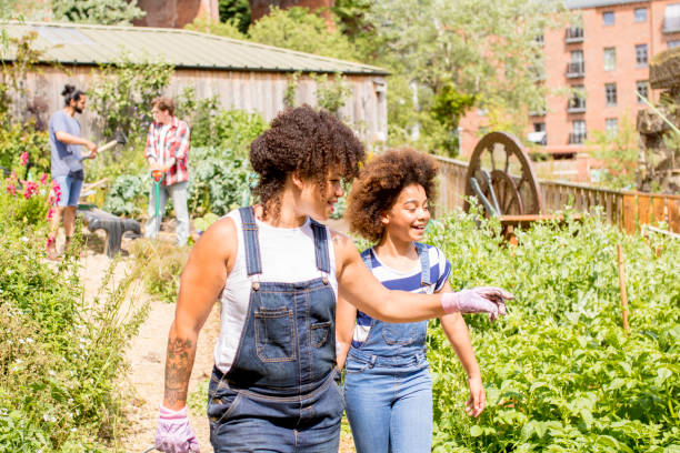 Exploring the Farm A woman and child walk through the farm community garden. community garden sign stock pictures, royalty-free photos & images