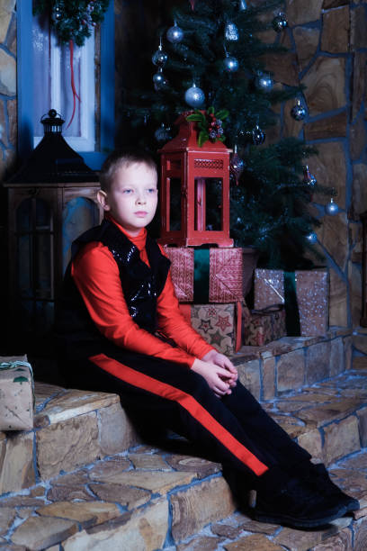 istock The boy is sitting under the tree with gifts 860948092