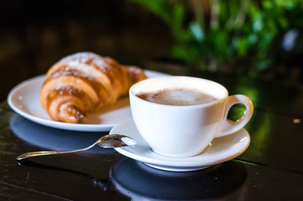 istock Coffee white cup, croissants on dark retro background, selective focus. Breakfast concept 860957818