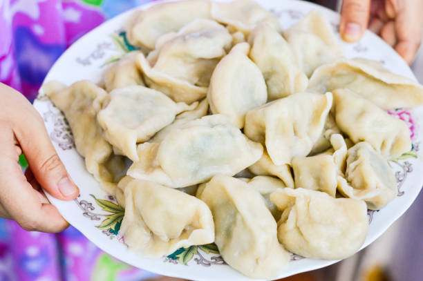 istock Two Hands Holding a Plate of Boiled Chinese Dumplings 860958122