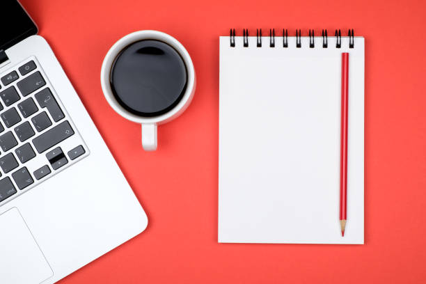 istock Modern red office desk table with laptop and blank notebook page for input the text. Top view, flat lay 860958274