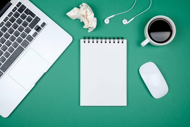 istock Modern designer office desk table with blank notebook page, laptop computer and cup of coffee. Top view, flat lay 860958362