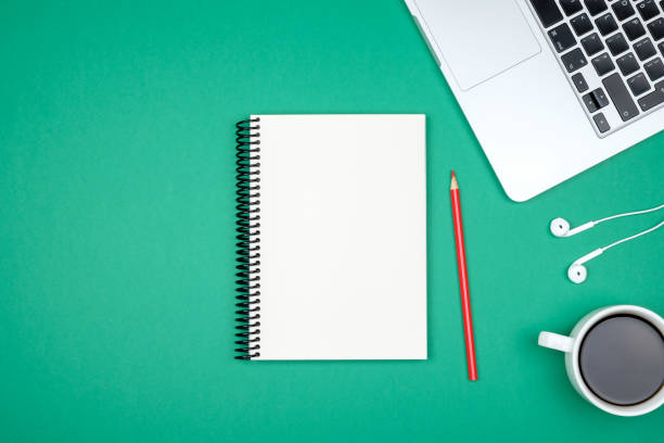 istock Modern green office desk table with laptop and blank notebook page for input the text. Top view, flat lay 860958414