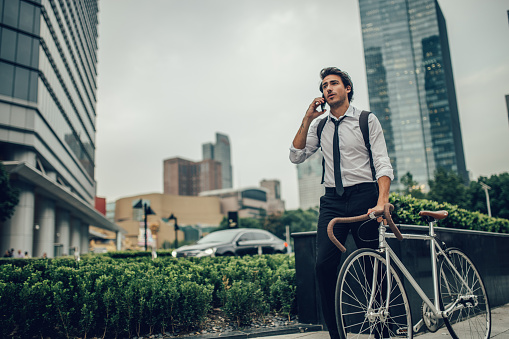 Young and handsome businessman wandering through the streets of a big city.