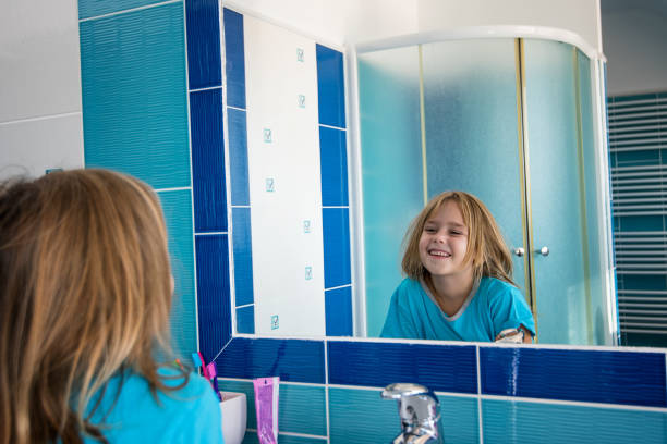istock Little girl in bathroom looking in mirror. 860959614