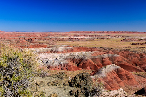 Brilliantly colored red hills of Arizona's Painted Desert stretch to the horizon. Beginning of the Petrified Forest National Park, Arizona.