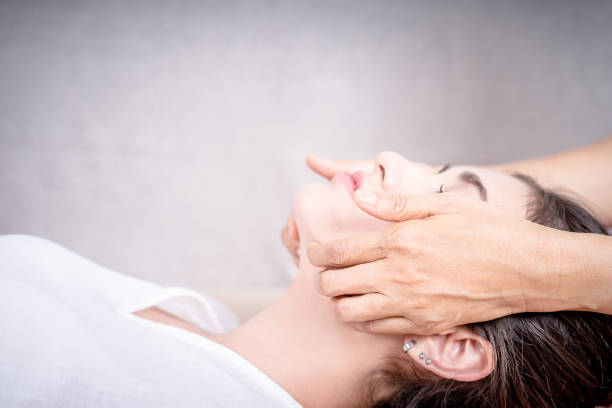 istock Asian Women is getting face massage side view with cement wall copy space 860971124