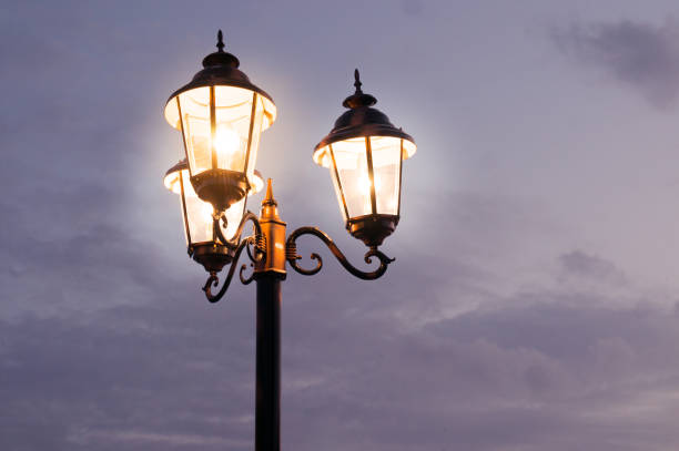 istock Old fashioned street lights shot against a cloudy sky 860979998