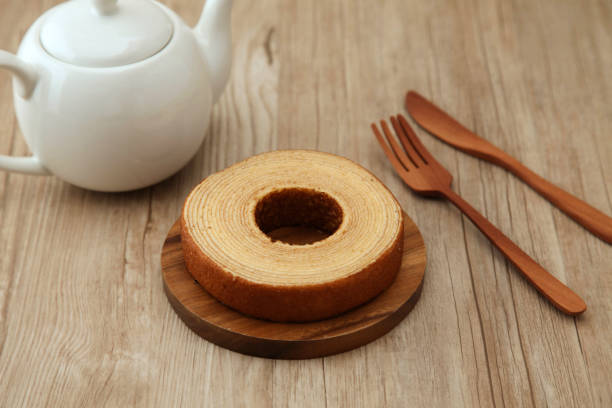 istock baumkuchen German doughnut cake on wood plate fork knife teapot on table 860980120