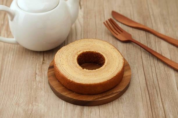 istock baumkuchen German doughnut cake on wood plate fork knife teapot on table 860980218