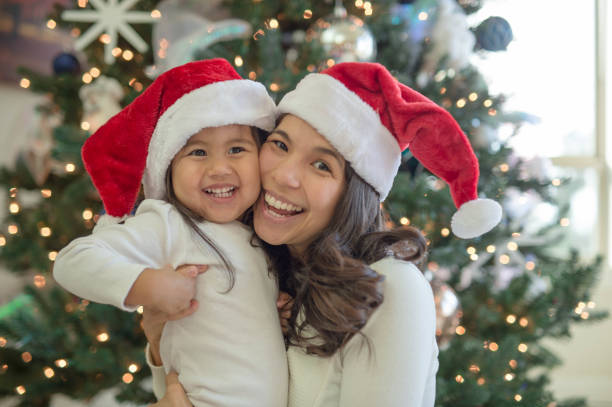 istock Young ethnic girl and her mom pose in elf hats 860981730