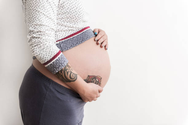 istock Pregnant woman putting hands on round paunch 860985304
