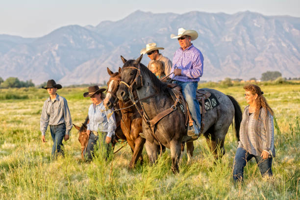 Cowboy family walk and ride horses in an open range including grandchildren and grandparents Cowboy family walk and ride horses in an open range including grandchildren and grandparents cowboy photos stock pictures, royalty-free photos & images