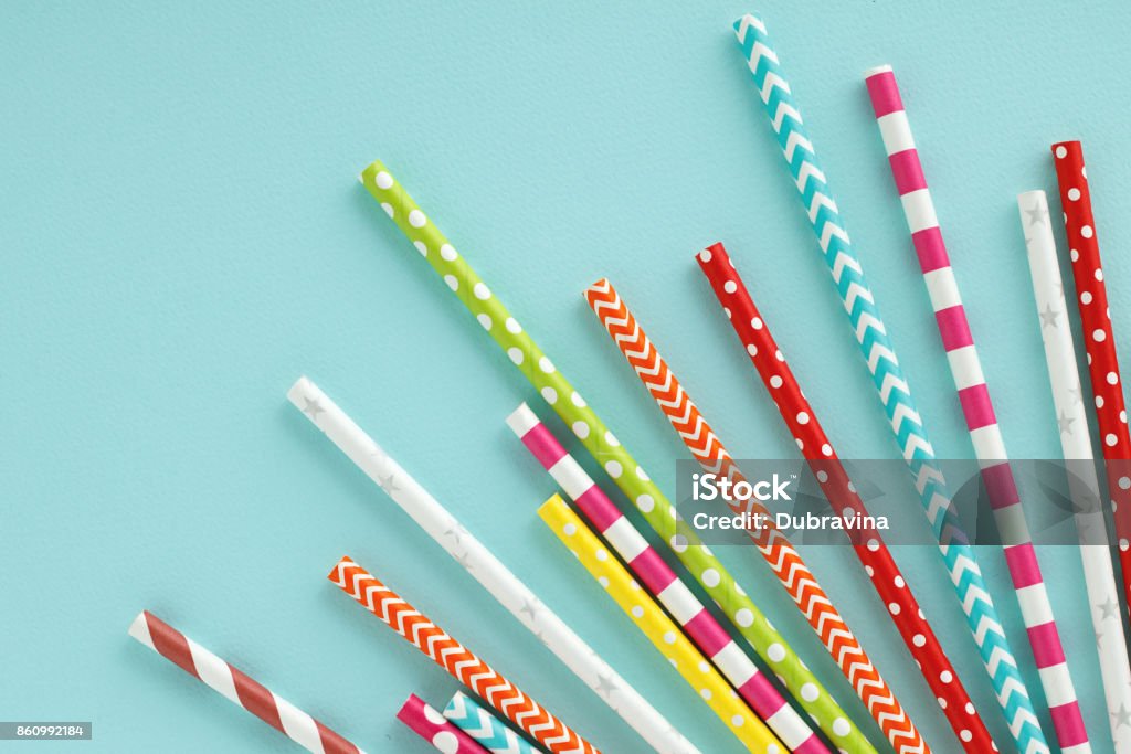 Colorful paper drinking straws on blue background. Colorful paper drinking straws on blue background. Flat lay with copy space. Drinking Straw Stock Photo