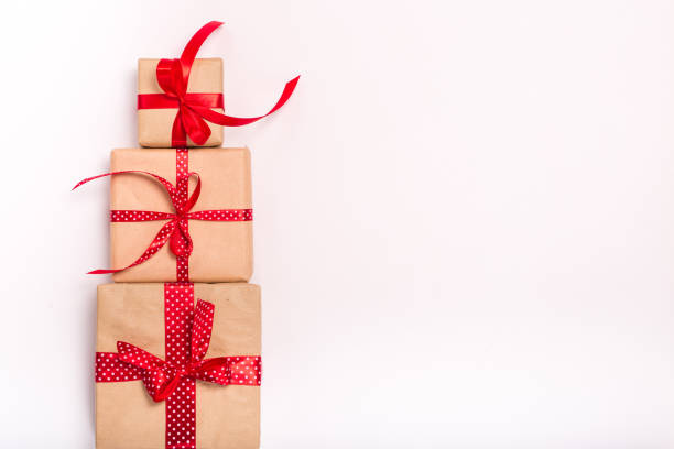 istock Square present gift boxes stack wrapped in craft paper with satin red ribbon bow knot top view 861004102