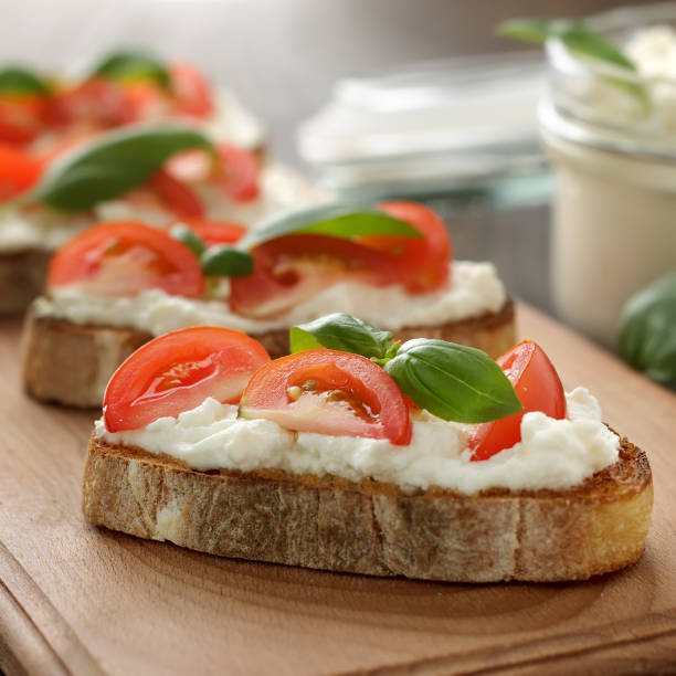 istock Italian bruschetta with cheese, tomato and basil on cutting board. 861004144