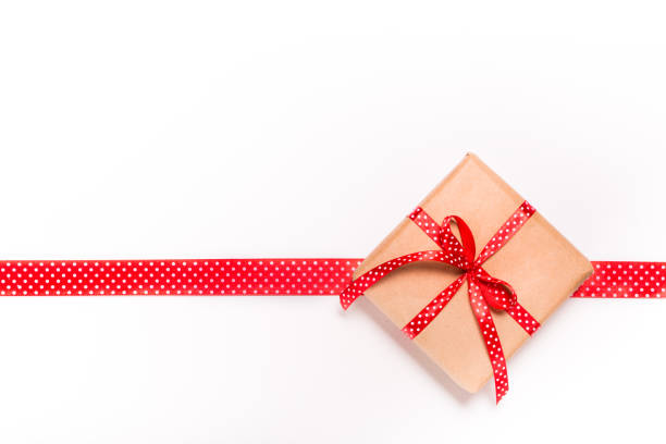 istock Square single one present gift box wrapped in craft paper with satin red ribbon bow knot top view 861004752