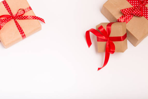 istock Square present gift boxes wrapped in craft paper with satin red ribbon bow knot top view 861012460