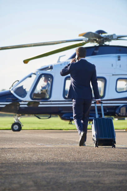 istock Businessman Walking Towards Helicopter Whilst Talking On Mobile Phone 861012486