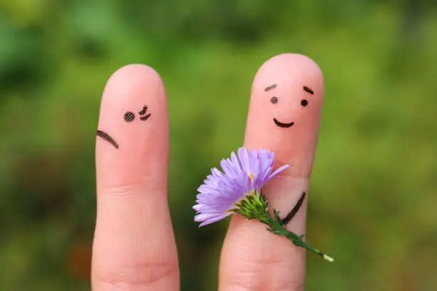 Fingers art of couple. Joyful man gives woman bouquet of flowers, she is not satisfied.