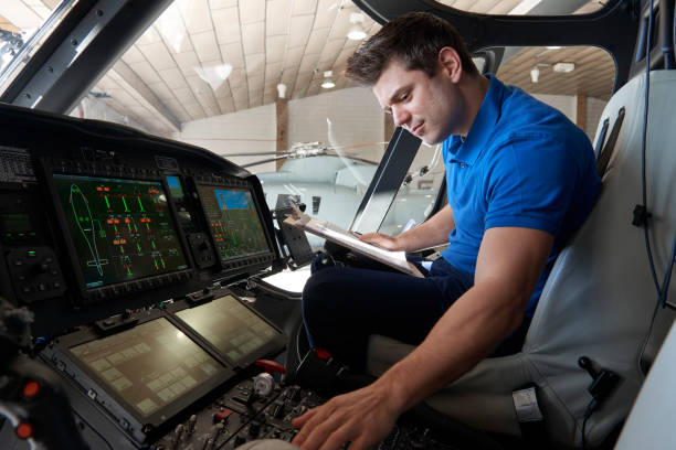 Male Aero Engineer With Clipboard Working In Helicopter Cockpit