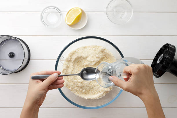 Step by step recipe galette or pie with nectarines. Female hands pour water from a jug into spoon for dough.