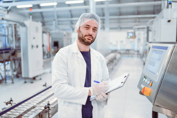 istock Young Handsome Smiling Scientist With Clipboard Posing in Factory 861014202