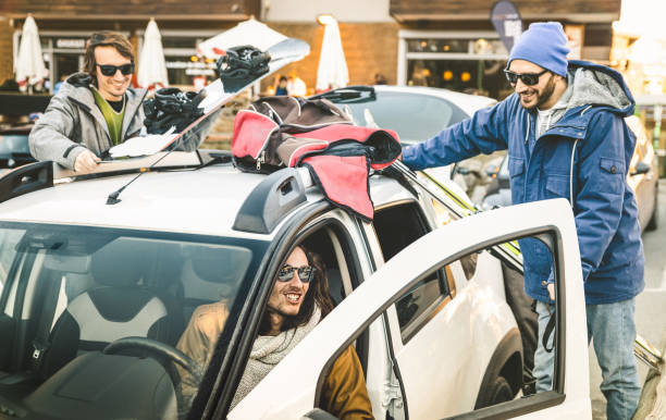 best friends having fun together preparing car for ski and snowboard at mountain trip - friendship hangout concept with young people loving winter sports travel - vintage desaturated contrast filter - apres ski winter friendship ski imagens e fotografias de stock