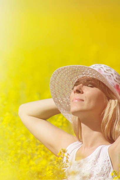 istock Young woman with a hat enjoying summer on the rape field. 861025854