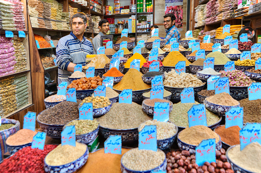 Fars Province, Shiraz: A shop with spices, grains and dried fruits, the seller stands next to the shop window.