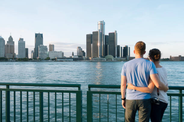 Young couple looking at Detroit skyline Young couple looking at Detroit skyline detroit michigan stock pictures, royalty-free photos & images