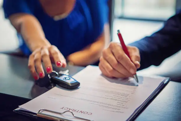 Couple is buying new car and signing the contract