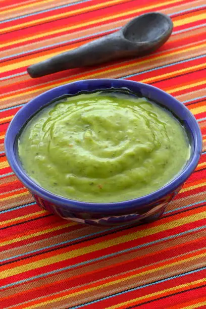 Mexican guacamole, prepared with fresh avocados, lemon juice, vinegar and hot and sweet peppers, on artisan  talavera pottery bowl