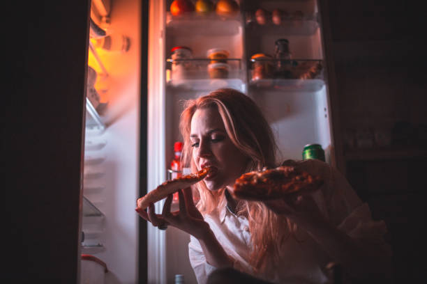 istock Beautiful woman eating pizza late night 861083374