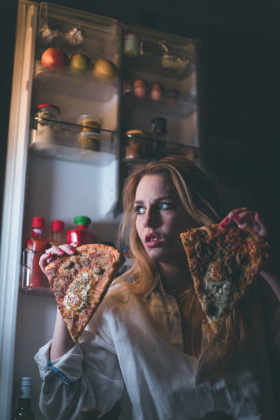 istock Beautiful woman eating pizza late night 861083700