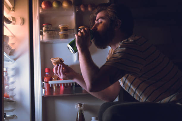 istock Bearded man eating and drinking beer during the night 861084076