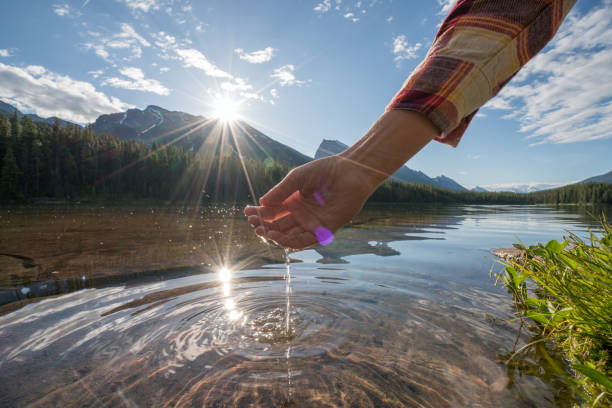 istock Human hand cupped to catch fresh water from mountain lake 861089966