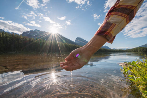 istock Human hand cupped to catch fresh water from mountain lake 861090046