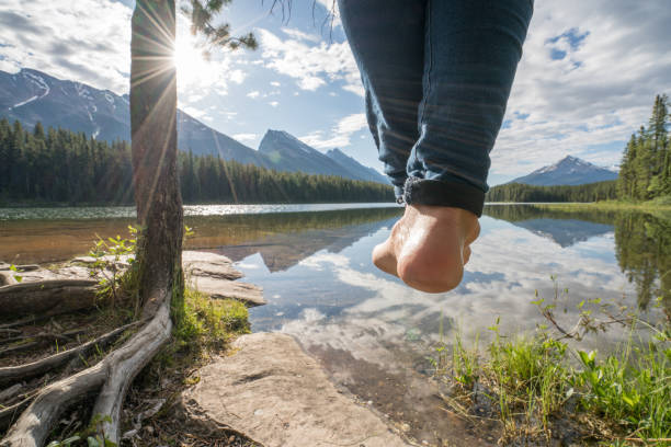 istock Woman's feet dangle from hammock, above lake 861101758