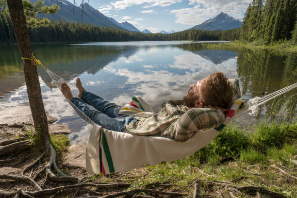 istock Young man relaxing on hammock by the lake 861104400