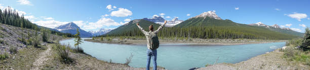 istock Panoramic of young man arms outstretched by the river 861107326