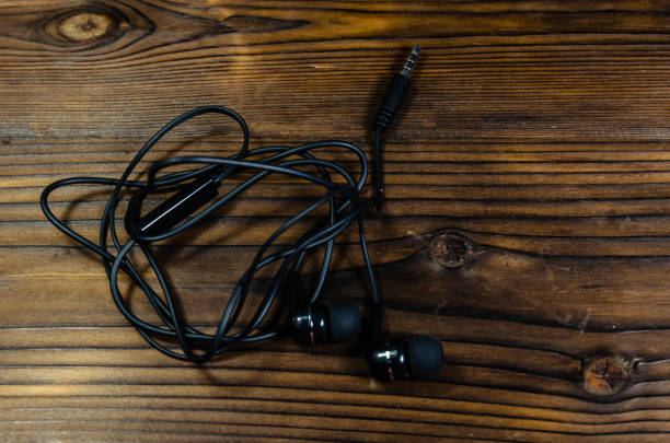 istock Black earphones on wooden table. Top view 861111314