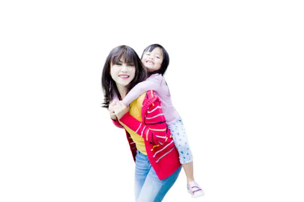Pretty woman playing a piggyback ride with her daughter in the studio, isolated on white background