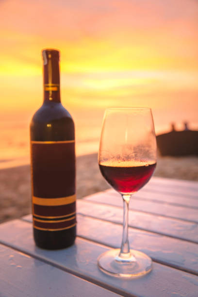 istock Red wine bottle & glass with sunset background 861126614