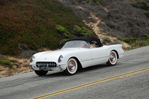 The last 1953 Corvette built; there were 300 Corvettes built that year, the first year the Corvette was available. Photographed at the Pebble Beach Tour d'Elegance on Pacific Coast Highway. White sports car convertible on scenic drive.