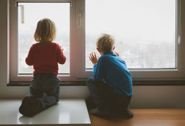 istock little girl and boy looking through the window 861133764