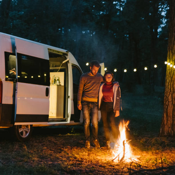istock Couple standing near the campfire in forest 861154330