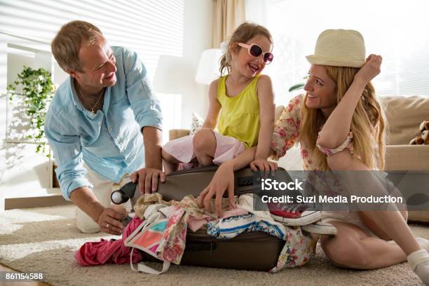 Happy Family Packing Suitcase Stock Photo - Download Image Now - Family, Vacations, Leaving