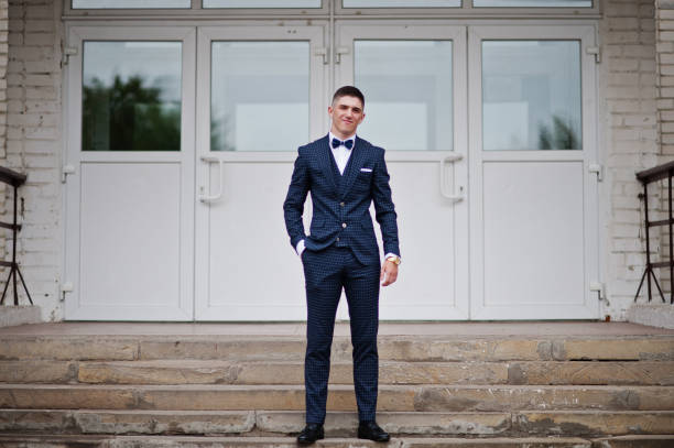 Portrait of a handsome high school graduate in stylish tuxedo posing on the stairs on the prom. Portrait of a handsome high school graduate in stylish tuxedo posing on the stairs on the prom. prom photos stock pictures, royalty-free photos & images