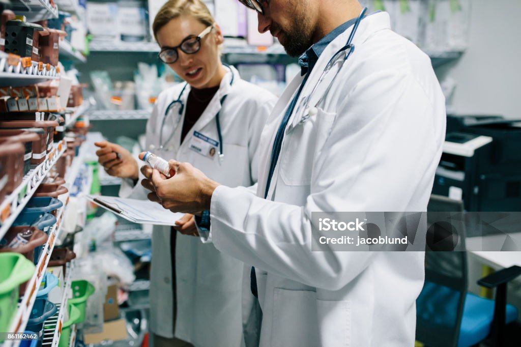 Pharmacists checking inventory at pharmacy Two chemist working in pharmacy drugstore. Male and female pharmacists checking inventory at pharmacy. Hospital Stock Photo
